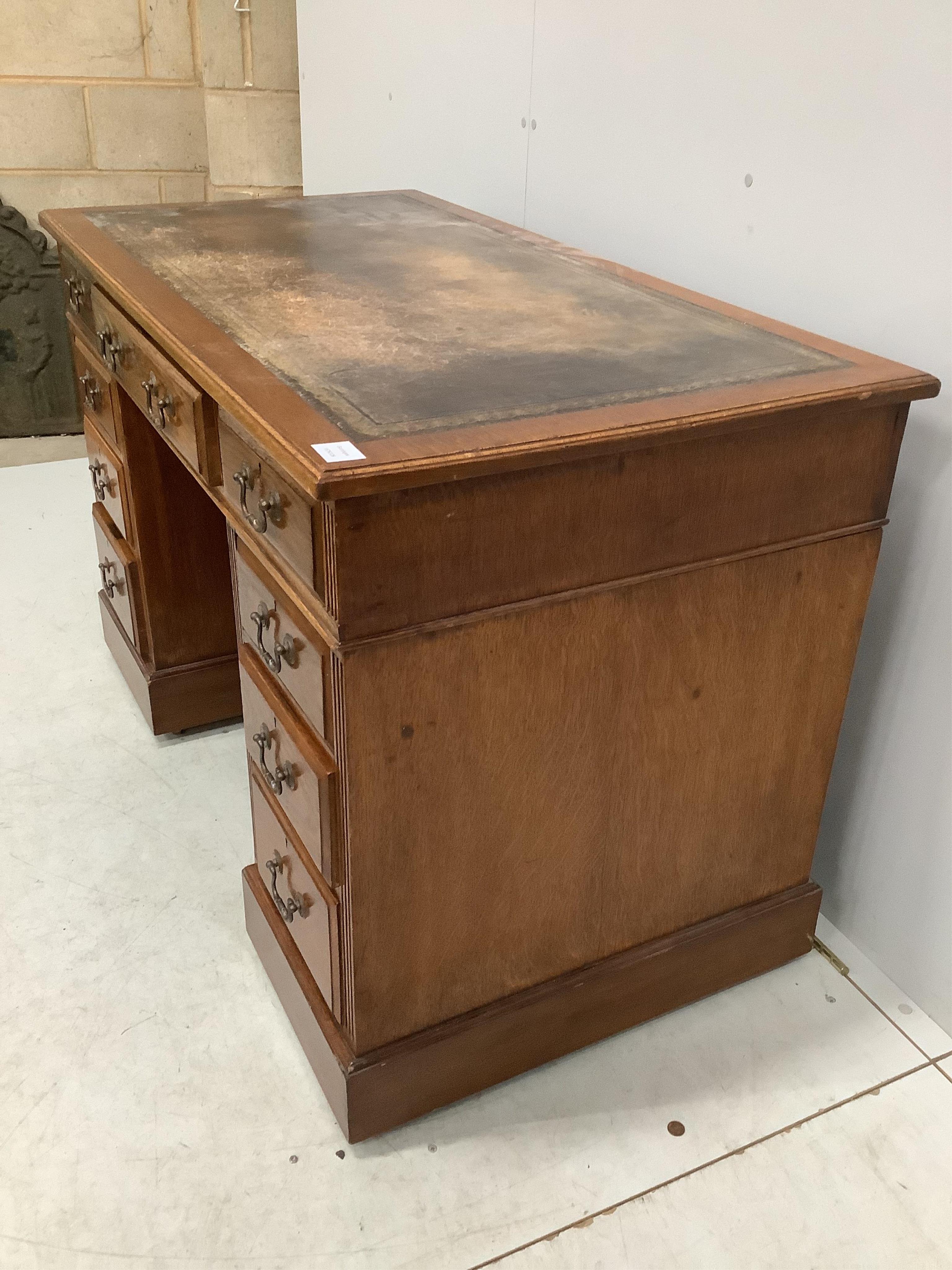 An early 20th century oak pedestal desk, fitted nine drawers, with a leather inset top, width 121cm, depth 64cm, height 78cm. Condition - fair